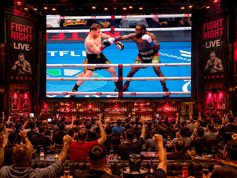 Fanáticos viendo una pelea de boxeo en el sports bar de Lambaré